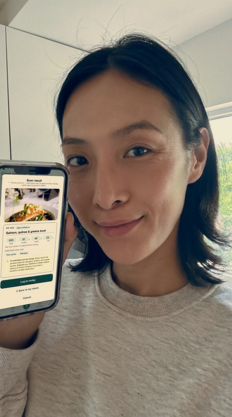 Melanie, a Plait Health member, holding her phone showing a Plait Health scan result